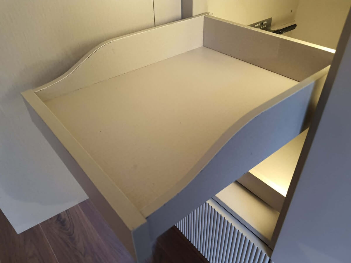 Drawer construction detail showing bottom-mounted channel and edge finish by SpaceTalk Designs