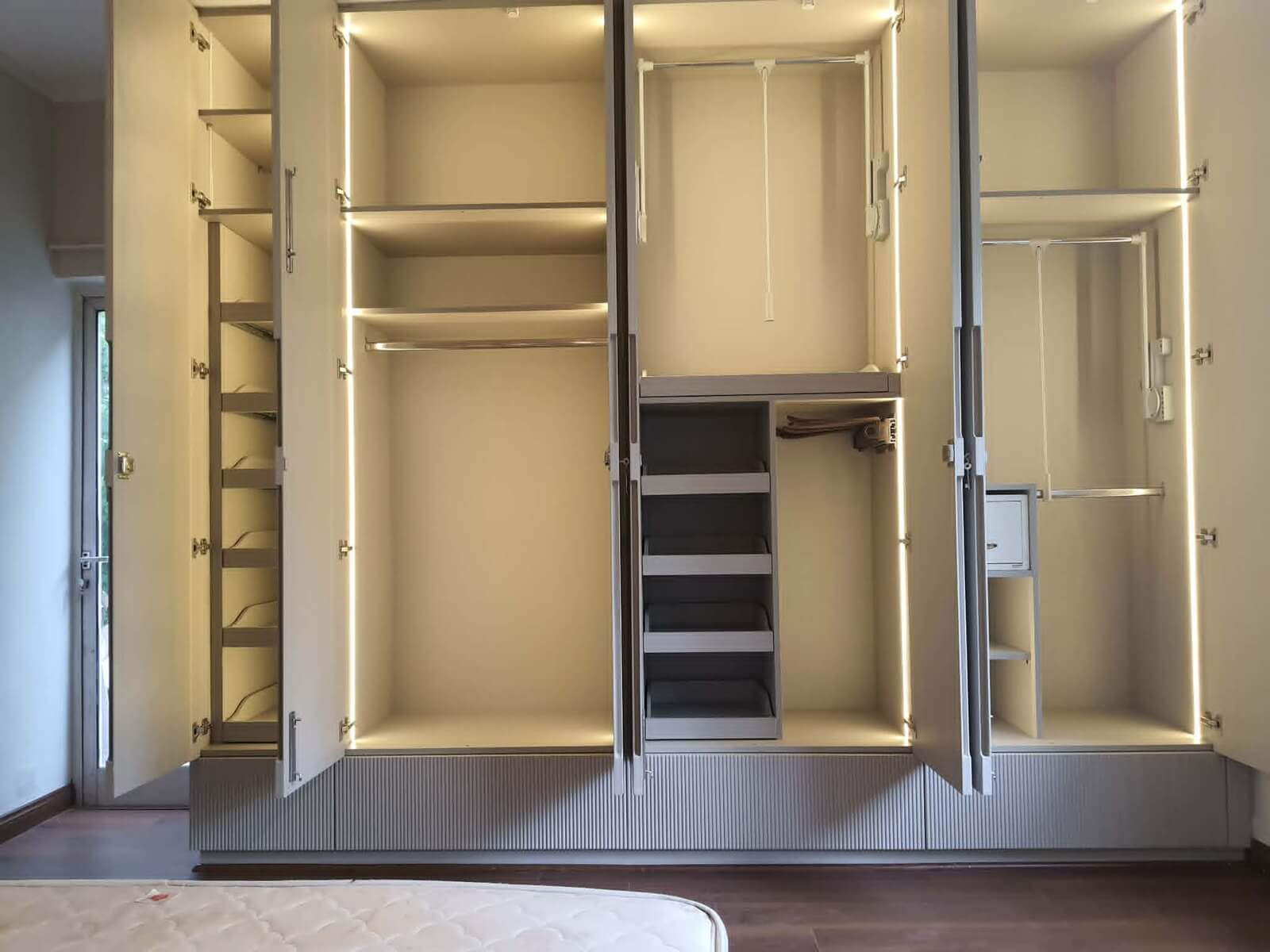 Custom wardrobe interior showing garment pull-downs, LED lighting, and drawer channels by SpaceTalk Designs
