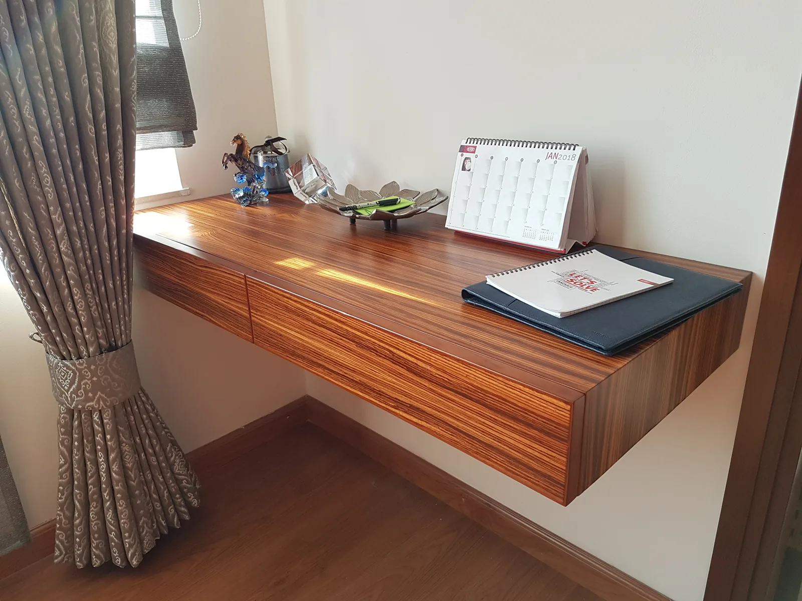 Wall-mounted floating study desk executed in rich matched veneer.
