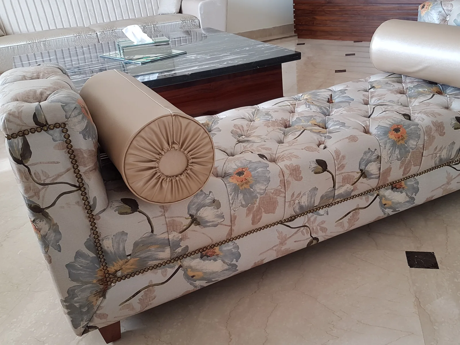 Custom floral tufted settee with bolster pillows.