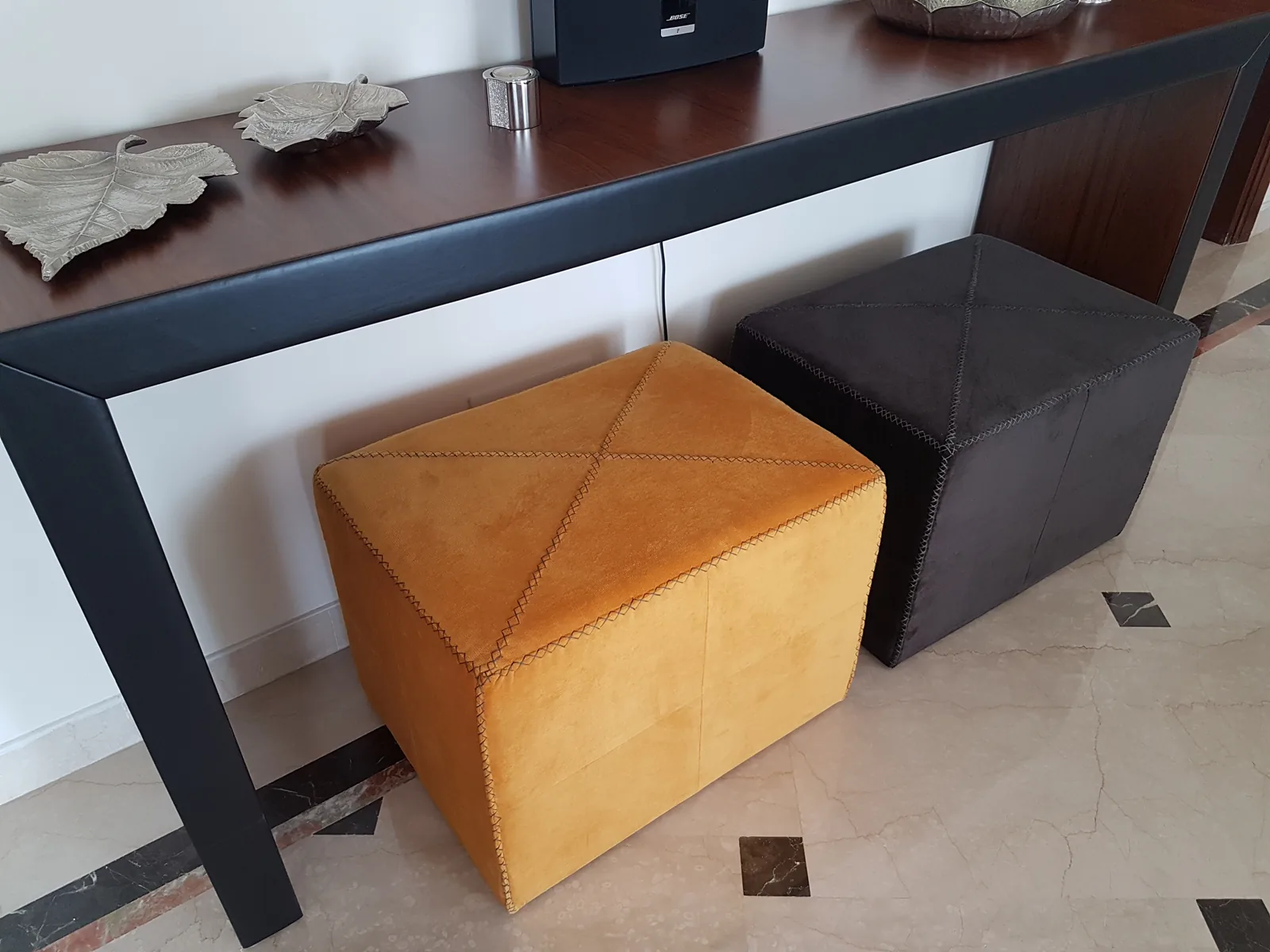 Nested leather poufs tucked under a console.