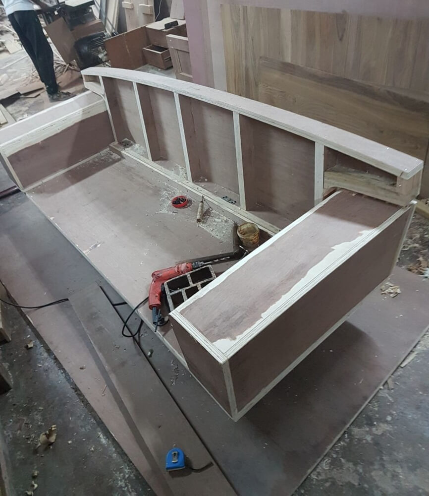 Exposed hardwood frame of a custom sofa during manufacturing in the factory.