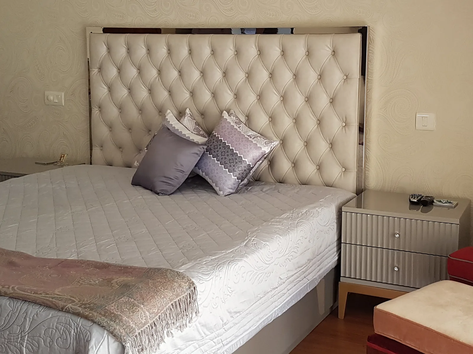 Monochromatic master bedroom featuring a custom tufted leather headboard.