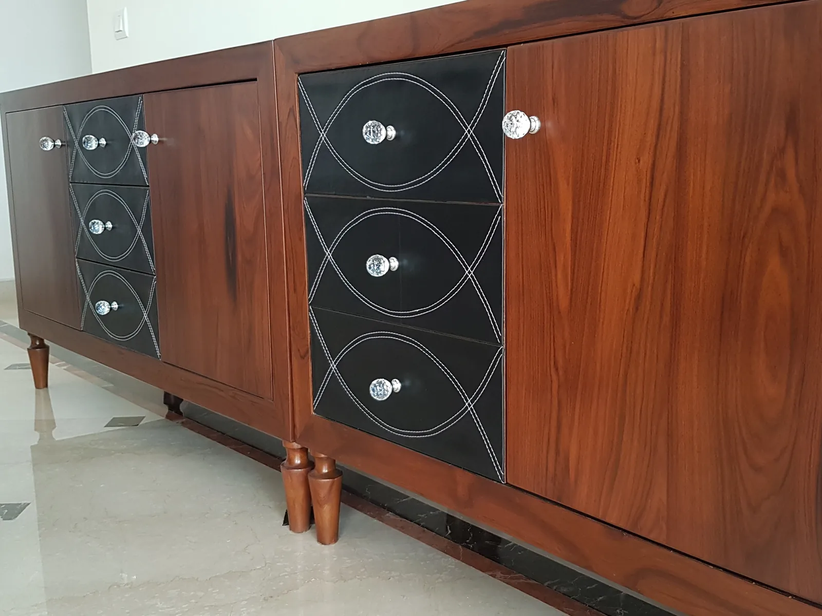 Walnut console table featuring custom leather-wrapped drawers.
