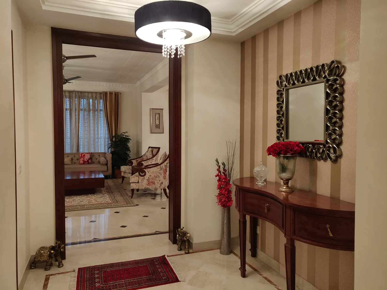 Entrance foyer with red stone inlay at Central Park 1, Golf Course Road, Gurgaon by SpaceTalk Designs