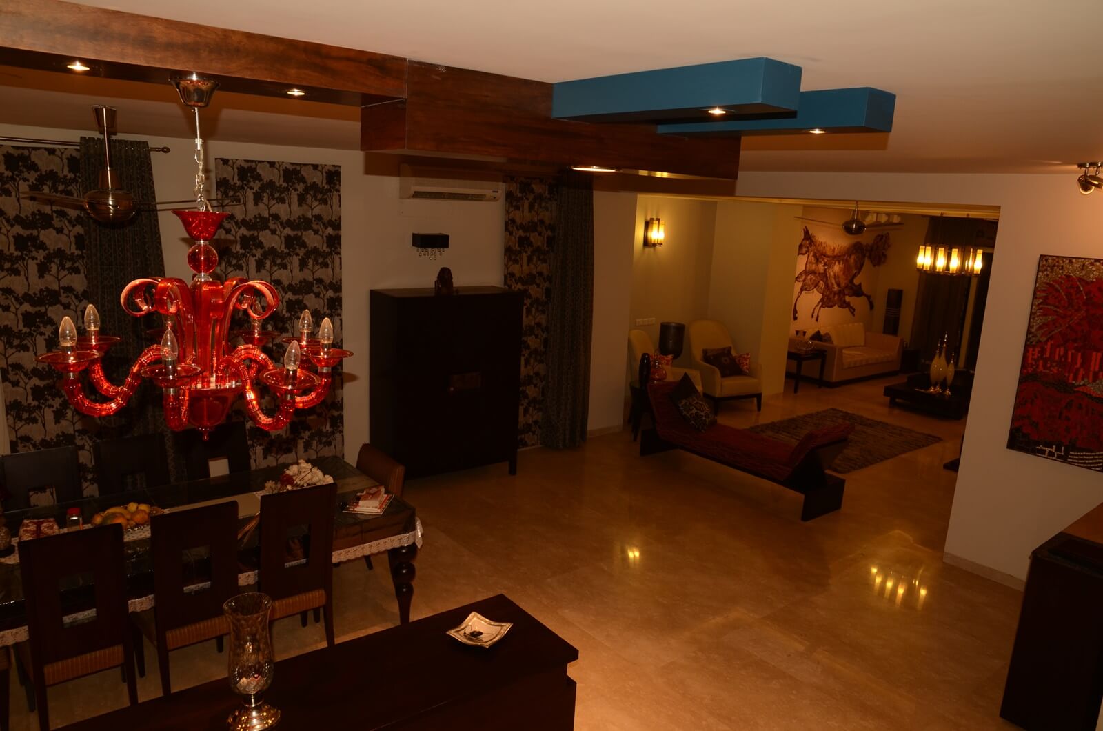 Wood beam ceiling and red chandelier at Palm Springs Villa, Gurgaon by SpaceTalk Designs