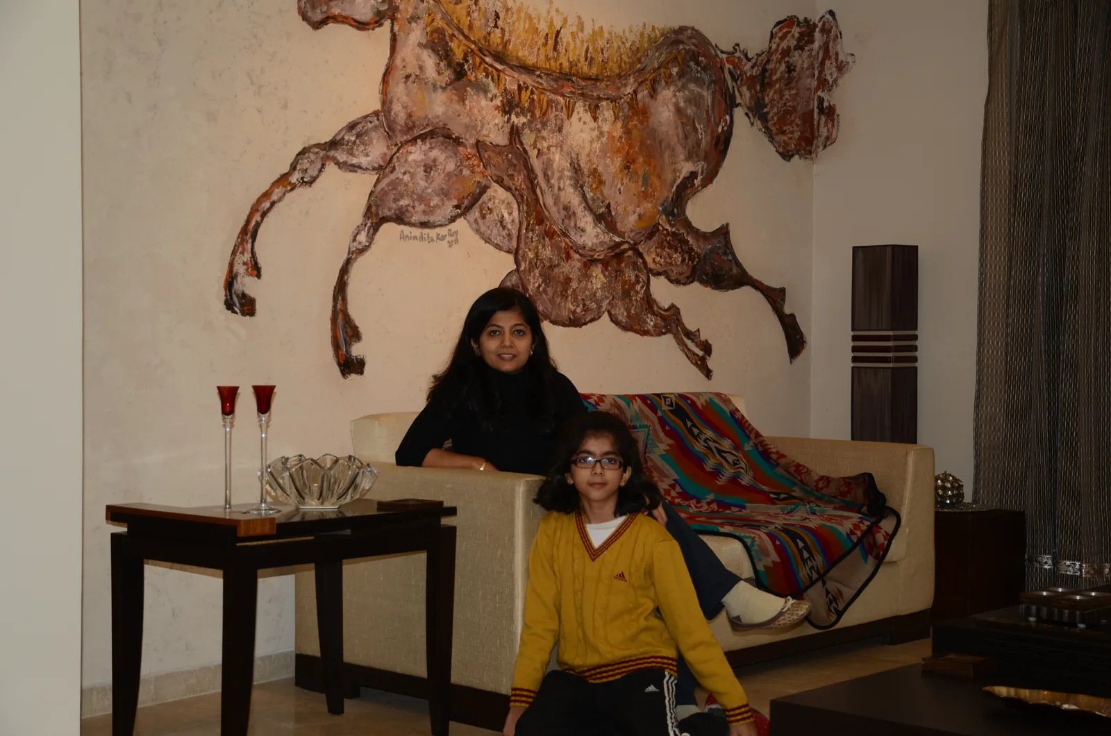 Family at home under commissioned wall fresco at Palm Springs Villa, Gurgaon by SpaceTalk Designs
